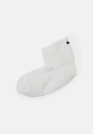 White ankle sock featuring textured fabric, a cushioned sole, and a small black logo on the ankle ribbing.