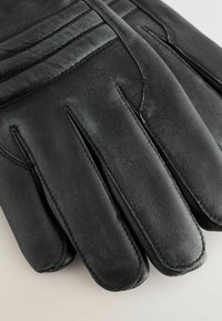 Czarne skórzane rękawiczki o gładkiej fakturze i subtelnych detalach przeszycia, z pięcioma palcami i dopasowanym krojem.