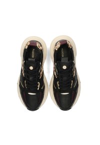 Sneakers neri e beige con bordi in stampa leopardata, lacci neri e suole spesse beige, visti dall'alto.