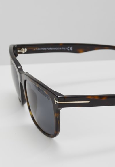 Tortoiseshell sunglasses with dark lenses, featuring a gold accent on the temples and a glossy finish. Marked "TOM FORD MADE IN ITALY."