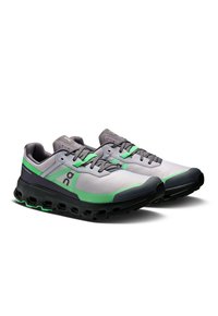 Chaussures de sport au design gris et vert, avec une tige en mesh respirant, des lacets et une semelle noire texturée avec des découpes pour le rembourrage.