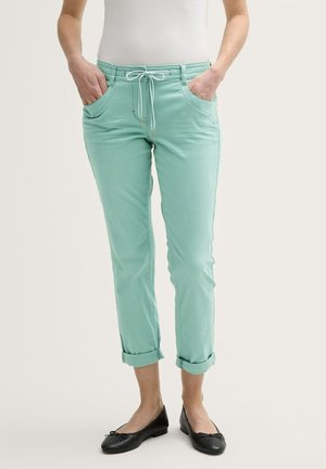 Mint green, tapered pants with rolled cuffs, drawstring closure, and front pockets. Smooth texture and contrast stitching detail visible.