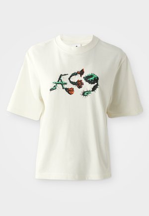 Kremfarget bomull T-skjorte med korte ermer, prydet med svart, grønt og oransje blomstermønster og stilisert tekst i midten.