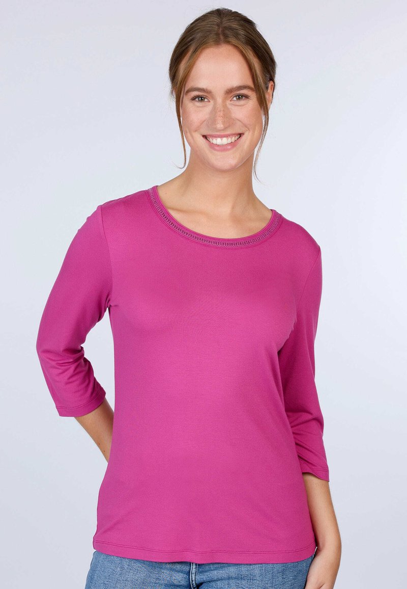 Fuchsia Langarm-T-Shirt mit rundem Halsausschnitt und Dreiviertelärmeln. Aus weichem Stoff gefertigt, mit glatter Textur und ohne sichtbare Muster.