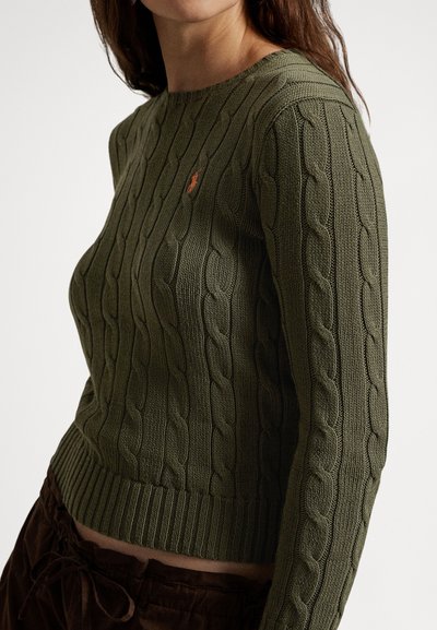 Alyvuogių žalia megzta megztinis su apvalia iškirpte ir briaunuotu apačios kraštu, ant krūtinės mažas oranžinis logotipas. Minkšta, tekstūruota medžiaga.