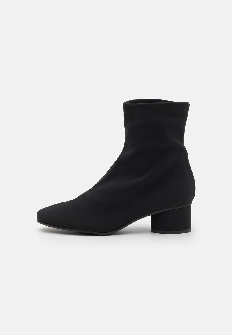 Mustad muste jalats pehme kangast ülaosa, kitsenev nina ja silindriline 2-tollise kandiga. Sile tekstuur, minimalistlik disain.