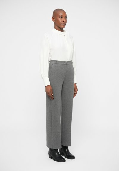 Gray wool blend wide-leg trousers with a high waist and button detail, paired with a white long-sleeve blouse. Black ankle boots complete the outfit.