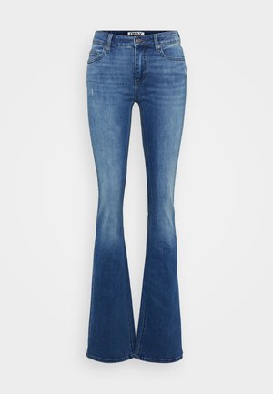 Jeans flare de denim azul com uma cintura alta, desbotamento subtil e um leve desgaste na frente. Apresenta um fecho com zíper e botão.