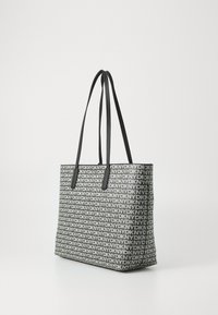 Τσάντα tote με γεωμετρικό μοτίβο μαύρου και λευκού λογότυπου, διαθέτει δύο μακριές μαύρες λαβές και σφιχτή μορφή. Υφασμάτινη επιφάνεια.
