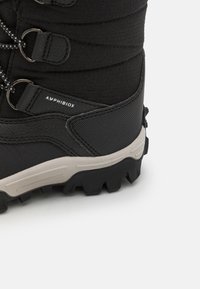 Botas de senderismo negras con un upper texturizado, acentos grises y una suela de goma resistente con un dibujo distintivo para tracción. Incluye ganchos metálicos.