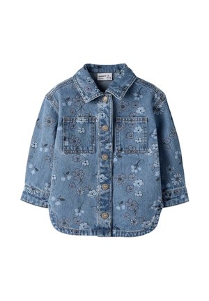 Veste en jean bleue à manches longues, boutonnée sur le devant, deux poches poitrine et motif floral clair.