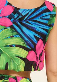 Kolorowy crop top z tropikalnym wzorem liści w odcieniach niebieskiego, zielonego i różowego na czarnym tle. Gładka faktura materiału.