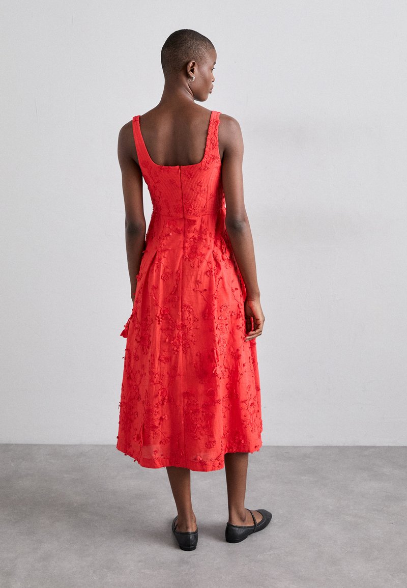 Abito midi rosso con ricami floreali, dotato di un corpo aderente e una gonna svasata, caratterizzato da spalline larghe e una cerniera nascosta sul retro.