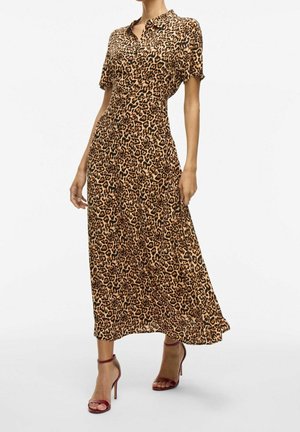 Femme portant une robe midi boutonnée à manches courtes imprimé léopard, associée à des sandales à talons hauts bordeaux avec bride à la cheville.