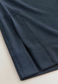 Chemise en coton bleu marine à manches courtes, avec une fente sur le côté et des ourlets cousus avec soin pour une finition soignée.