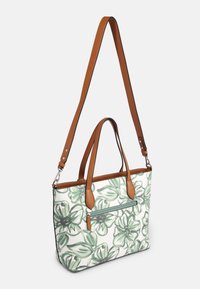 Olkalaukku, jossa on vihreä-valkoinen kukkakuvio, ruskeat nahkahihnat, vetoketjullinen etutasku ja sileäpintainen viimeistely.