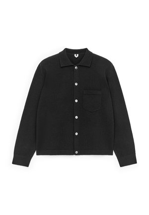 Black button-up cardigan made of soft fabric. Features a collar, long sleeves, and a chest pocket. Buttons are white. Smooth texture.