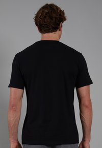 Black short-sleeve t-shirt made of cotton, featuring a crew neckline and smooth texture, displayed from the back.