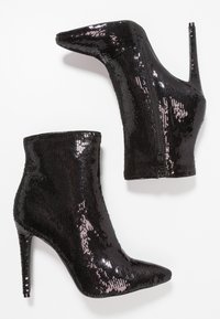 Černé kotníkové boty na vysokém podpatku pokryté flitry, špičatou špičkou, zipem na zadní straně a tenkým jehlovým podpatkem.