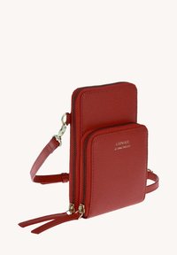 Porte-monnaie en cuir rouge en bandoulière avec deux compartiments zippés, surface texturée, accents en métal doré, et une bandoulière ajustable.