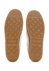 Paire de chaussures blanches vues par la semelle, avec des semelles extérieures en caoutchouc marron à motif losange et logo Tommy Hilfiger.