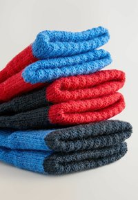 Juego de tres calcetines de punto: rojo, azul y gris oscuro. Cada par presenta una textura acanalada y diseños de puntera en contraste.
