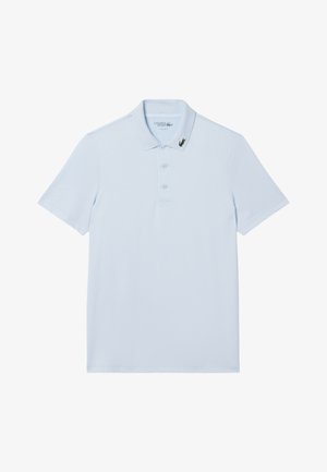 Polo a maniche corte colore azzurro chiaro con tre bottoni e un piccolo logo di coccodrillo verde sul colletto sinistro.