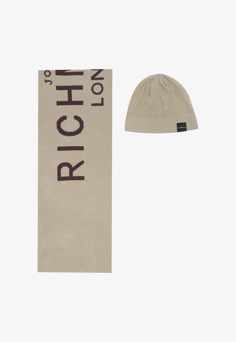 Sciarpa beige con testo marrone scuro recante la scritta "RICHMOND LONDON". Accompagnata da un berretto beige abbinato con un'etichetta del logo nera.