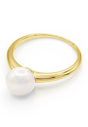 Bague en bande d’or avec une seule grosse perle blanche posée sur le dessus, présentée sur fond blanc.