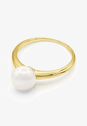 Bague en bande d’or avec une seule grosse perle blanche posée sur le dessus, présentée sur fond blanc.