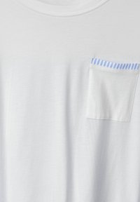 Bílé bavlněné tričko s kulatým výstřihem, s malou kapesní modro pruhovanou kapsou na levé straně. Měkká textura, jednoduchý design.