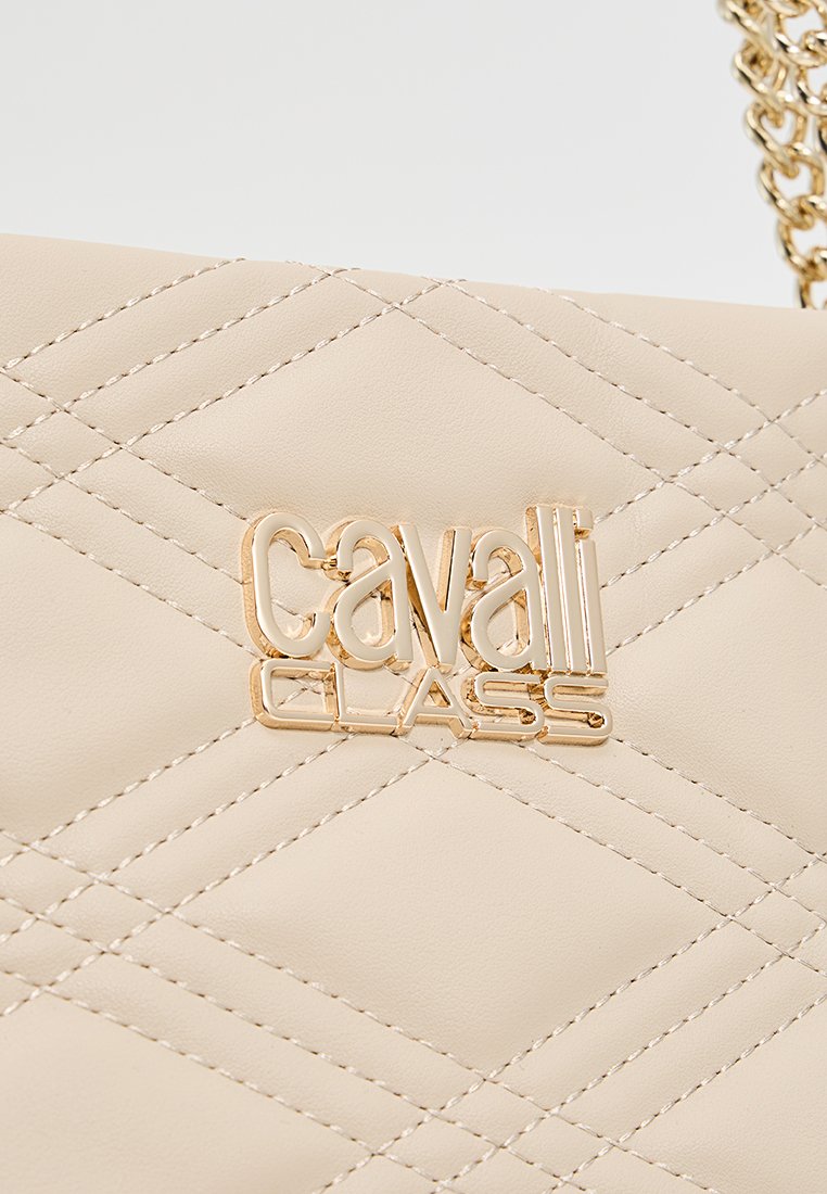 Bolso de piel acolchada beige con un logo metálico dorado "Cavalli CLASS" destacado en la parte frontal. Incluye un strap de cadena.
