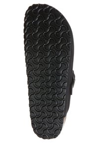 Schwarze Sandalensohle mit einem strukturierten, gewellten Muster für Traktion, einem glatten Rand und einem erhöhten Seitenprofil.