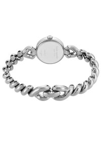 Reloj de metal plateado con una pulsera de eslabones gruesos y una caja redonda. Presenta un acabado suave y una pequeña corona en el lateral.