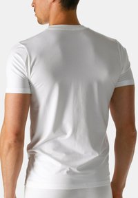 T-shirt bianca a maniche corte realizzata in morbido cotone. Design aderente con scollo a girocollo e spalle senza cuciture. Stile pulito e minimale.