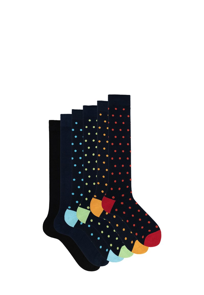Sieben Paar kniehohe Socken in dunklen Farben, die verschiedene gepunktete Muster und kontrastierende Zehenakzente in Blau, Orange und Grün aufweisen.