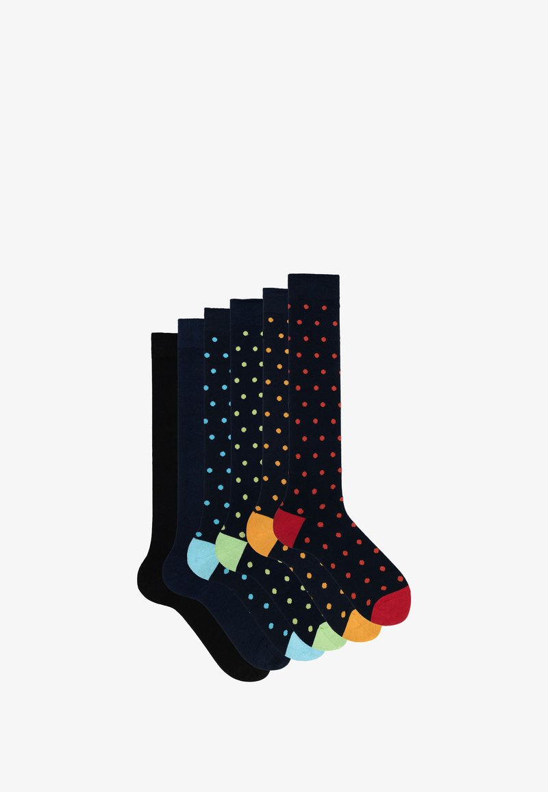 Sieben Paar kniehohe Socken in dunklen Farben, die verschiedene gepunktete Muster und kontrastierende Zehenakzente in Blau, Orange und Grün aufweisen.
