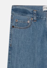 Ljusblå denimjeans med rak skärning, som har kopparnitar, kontrasterande sömmar och en liten framficka. Etiketter synliga vid midjebandet.