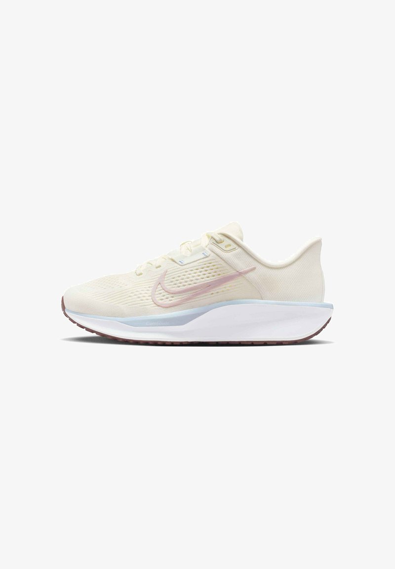 Light beige athletic shoe with a textured upper, pink swoosh accent, white midsole, and maroon outsole. Features breathable mesh design.