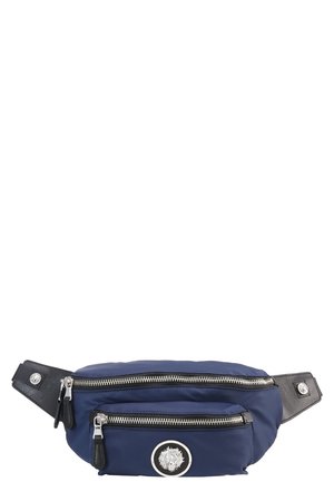 Sac banane bleu marine avec deux fermetures éclair argentées et un emblème circulaire de lion argenté sur la poche avant, fixé à des sangles en cuir noir avec boutons-pression.
