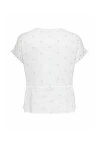 Blouse blanche à manches courtes avec des motifs croisés subtils et des manches retroussées, vue de dos sur un fond blanc uni.