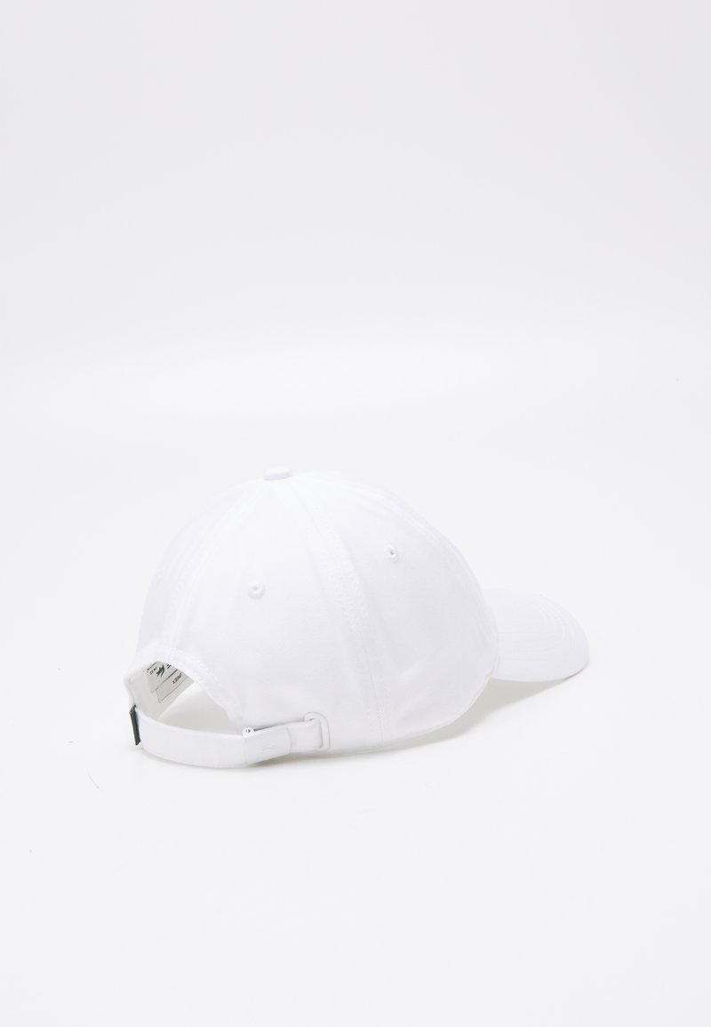 Gorra de béisbol blanca con corona redonda y visera curvada. Correa ajustable en la parte posterior. Material de algodón con agujeros de ventilación para transpirabilidad.