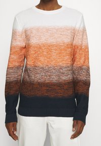 Maglione a maglia con strisce orizzontali in gradiente bianco, arancione e blu scuro. Polsini e orlo a coste. Tessuto texturizzato con tonalità variabili.