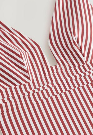 Rød- og hvidstripet stof med en v-hals design med spidse kanter og en vandret søm ved taljen. Glat tekstur, let materiale.