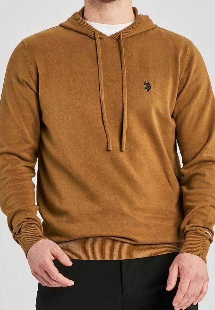 Mann trägt einen braunen Kapuzenpullover mit Kordelzügen, einem kleinen schwarzen gestickten Logo auf der Brust und schwarzen Hosen.