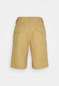 Rückansicht von beigen, knielangen Shorts mit zwei Klappentaschen auf der Rückseite und Gürtelschlaufen am Bund vor einem einfarbigen Hintergrund.