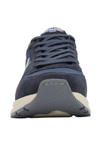 Sneaker blu scuro con suola grigia spessa, cuciture dettagliate, lacci larghi scuri e logo sul lato, vista dall'anteriore centrale.