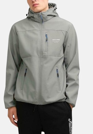 Chaqueta impermeable gris claro con capucha, bolsillos con cremallera y acentos azules. Presenta un logo en el pecho y un acabado suave y texturizado.