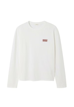 Ilga balta medvilninė marškinėliai su ilgomis rankovėmis, kuriuose kairiajame krūtinės šone yra mažas raudonas "AMERICAN VINTAGE" užrašas. Apvalaus kaklo dizainas, laisvas sijonas.