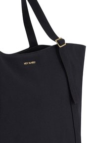 Zwarte canvas schoudertas met een gouden logo, voorzien van twee stevige schouderriemen en een gestructureerde vorm. Minimalistisch ontwerp met textuurstof.